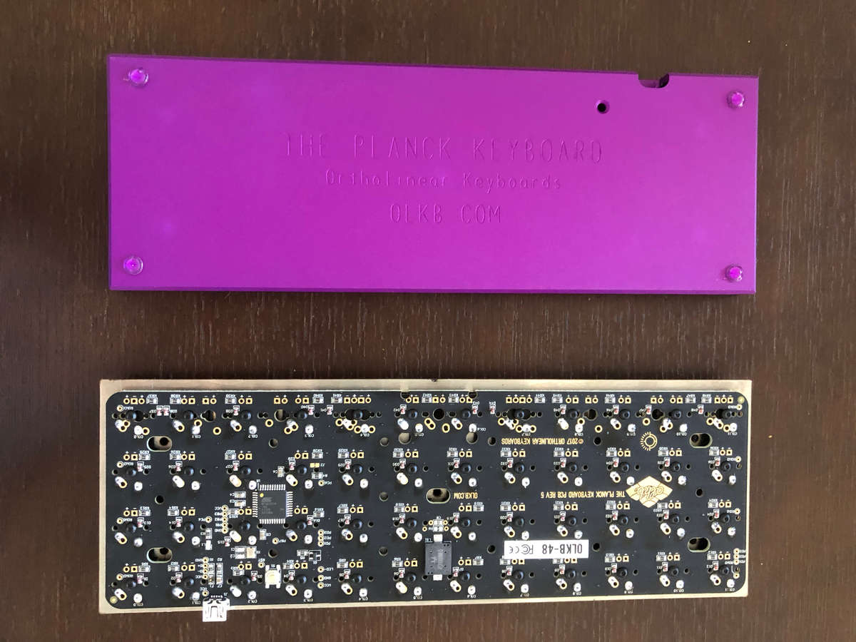 Photo of top plate, PCB, and switches alongside milled bottom with feet